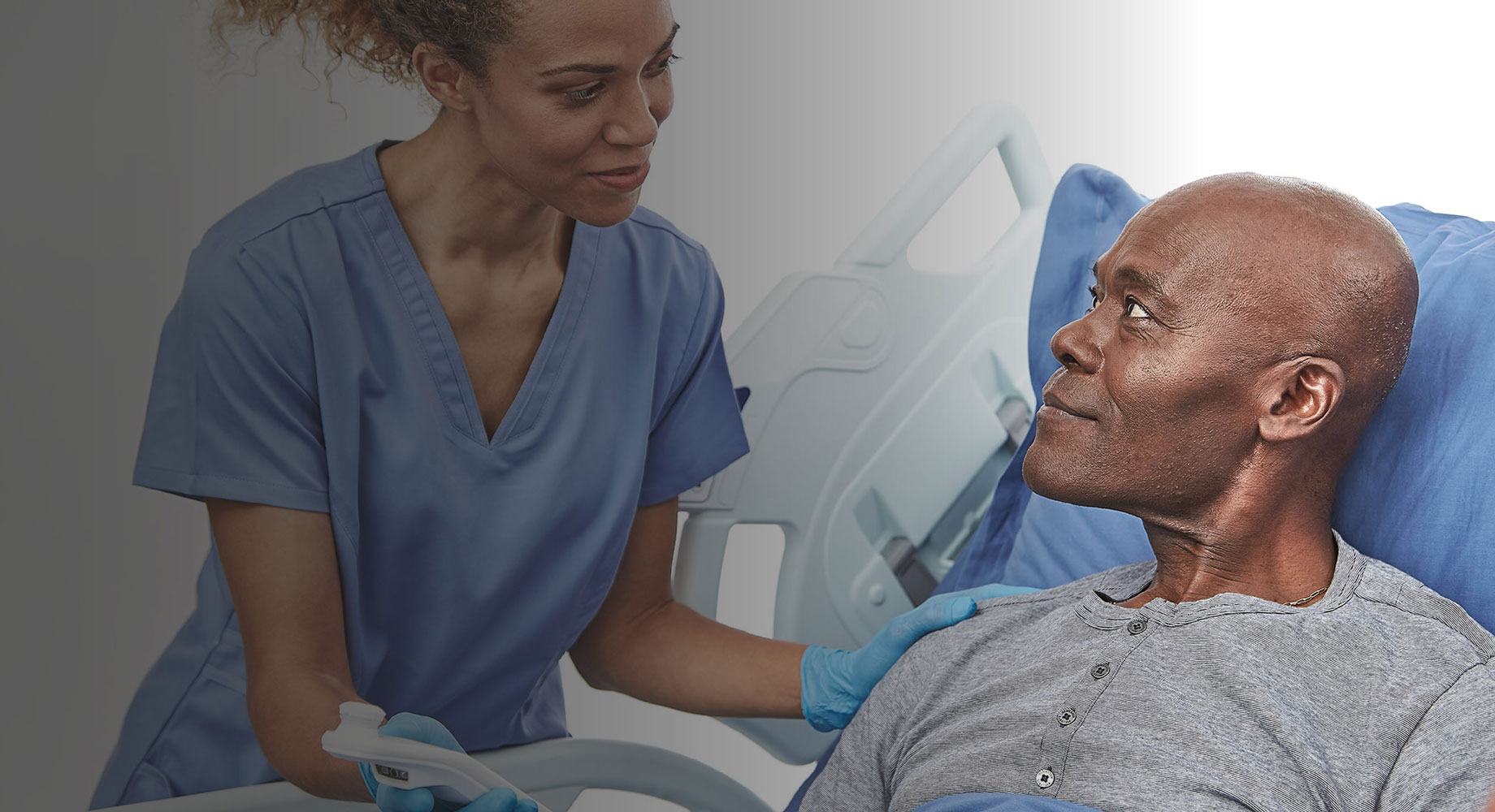 dark skin toned female nurse showing dark skinned toned male patient the Provizio SEM scanner